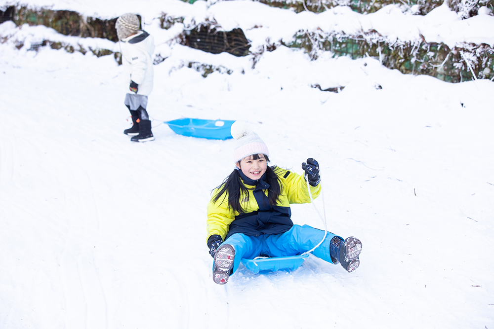 ソリで遊ぶ子ども